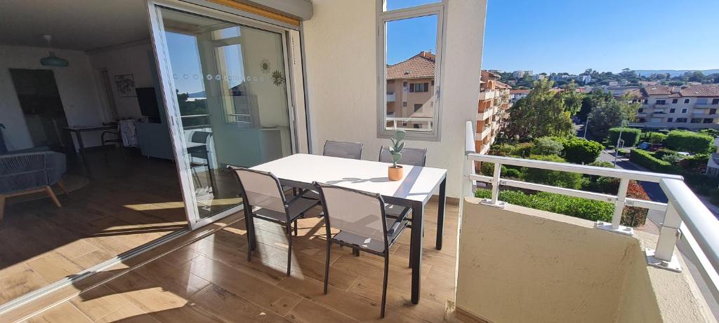une table blanche et des chaises sur un balcon avec vue dans l'établissement T3, 2ch, classé 3,parking gratuit sur place à 600m de la plage, des commerces ,du port proche st tropez, à Cavalaire-sur-Mer