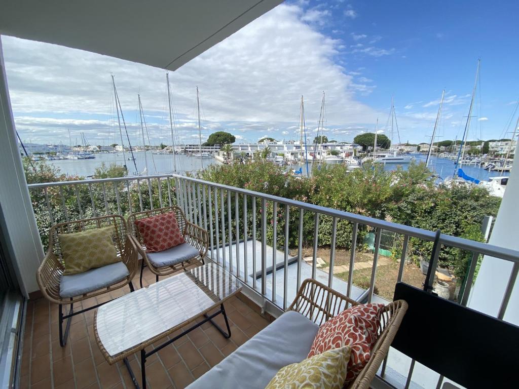 d'un balcon avec des chaises et des tables offrant une vue sur le port de plaisance. dans l'établissement Sol-y-Days Santa Maria vue sur les marinas, au Grau-du-Roi