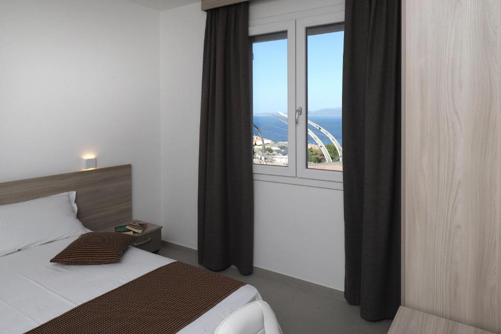 una camera da letto con un letto e una grande finestra di The Square Castelsardo a Castelsardo
