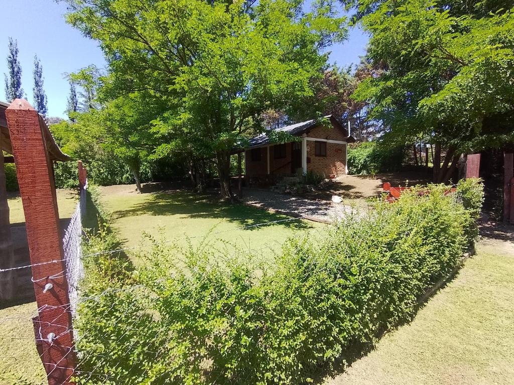 Un patio con una cerca y una casa en Cabaña Los ALAMOS, en Los Reartes