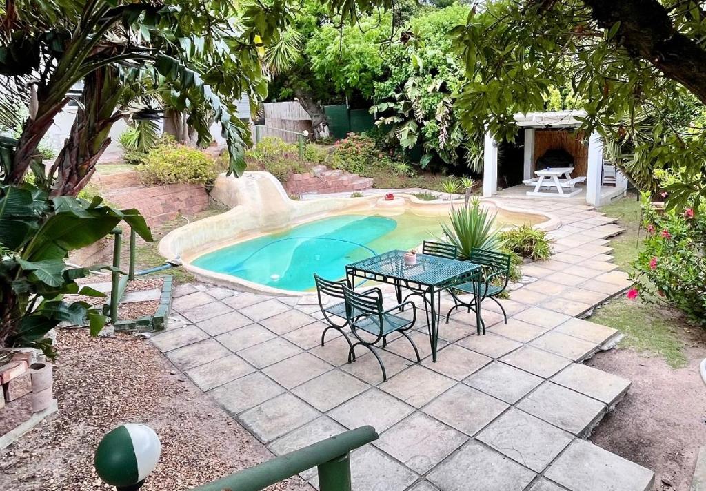 a patio with a table and chairs next to a pool at Table View Lodge in Cape Town