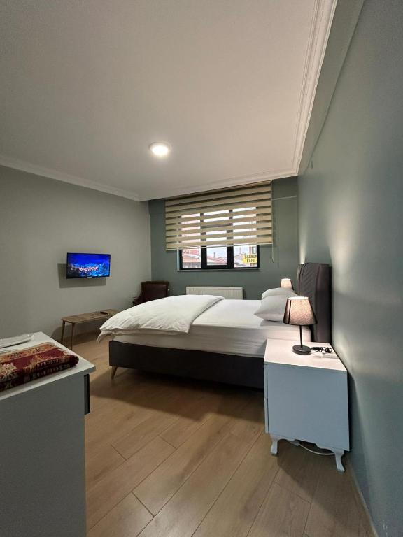 アールにあるBüyük Ağrı Otel & Apartの大きなベッドとテレビのある寝室