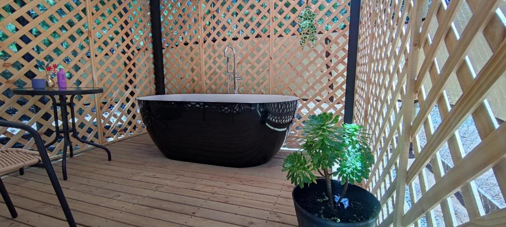 a large black tub sitting on a deck with two plants at Cabañas Pinos del Mar in Algarrobo