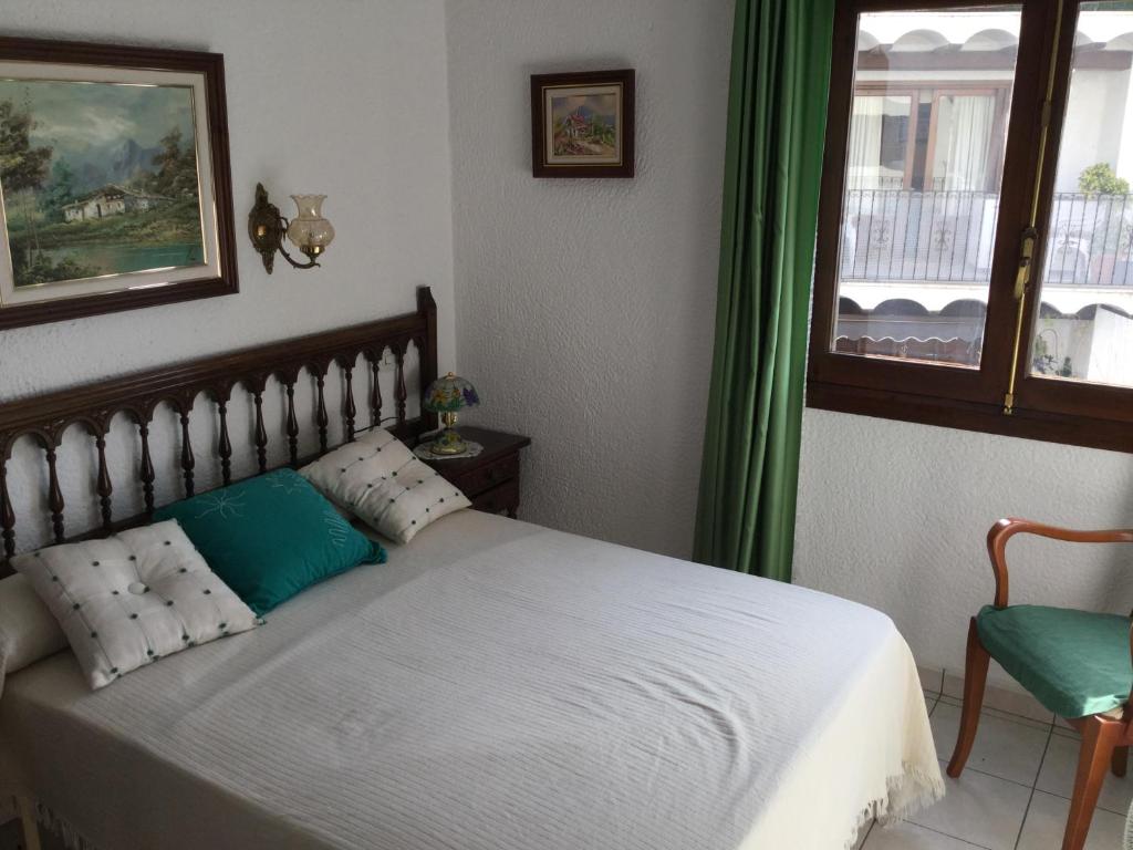モライラにあるLa Casonaのベッドルーム1室(緑のカーテンと窓付きのベッド1台付)