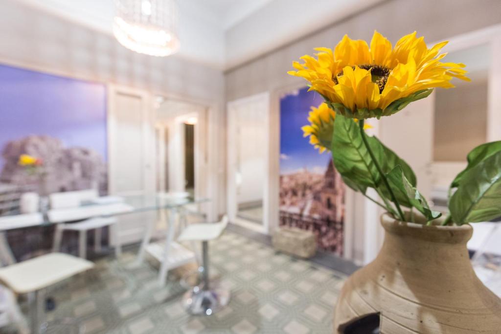 a vase with a yellow flower in a room at Matera In Vacanza in Matera