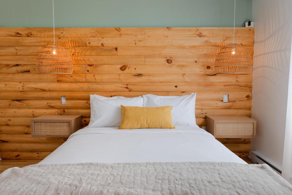 ein Schlafzimmer mit einem Bett mit einer Holzwand in der Unterkunft #10 - Serene Studio - Self Check in - Plateau - St-Denis - AC - TV in Montreal