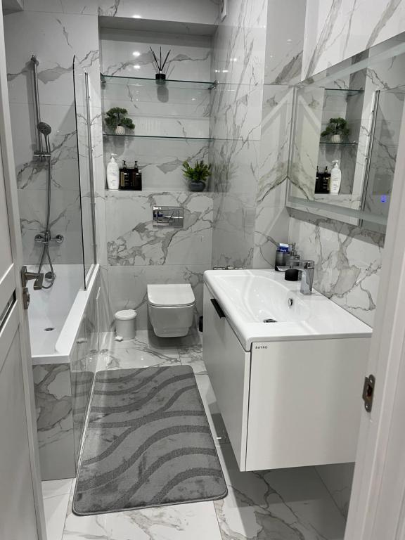 a white bathroom with a sink and a toilet at 1008 Apartment с living Кишинев Центр in Chişinău