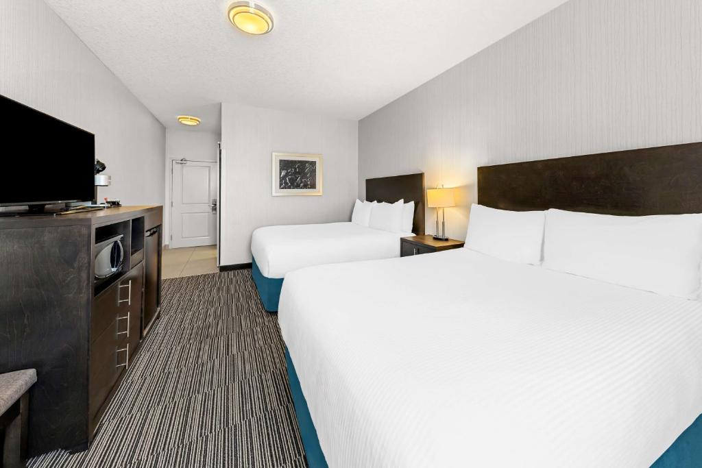 Rúm í herbergi á Best Western Plus Airdrie Gateway
