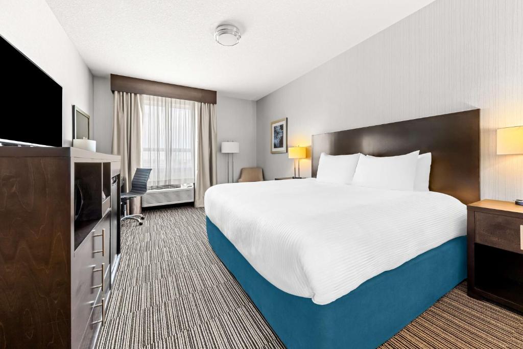 Rúm í herbergi á Best Western Plus Airdrie Gateway