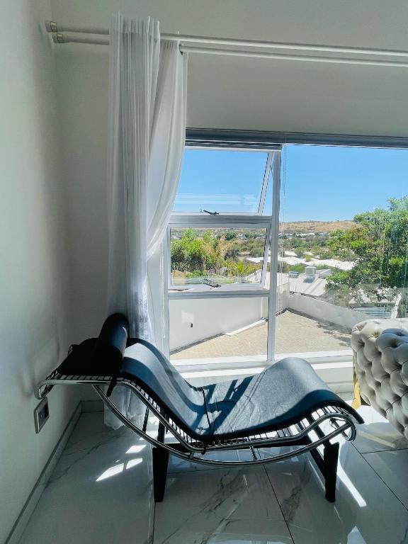 a room with a chair in front of a window at Avis sunrise view in Windhoek