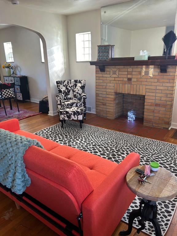 un soggiorno con un divano rosso e un camino di The Lloyd Little House a Pittsburgh