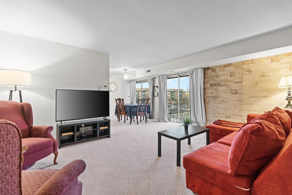 a living room with red furniture and a flat screen tv at Your perfect stay - Cozy 2BR apartment in NOVA in Arlington