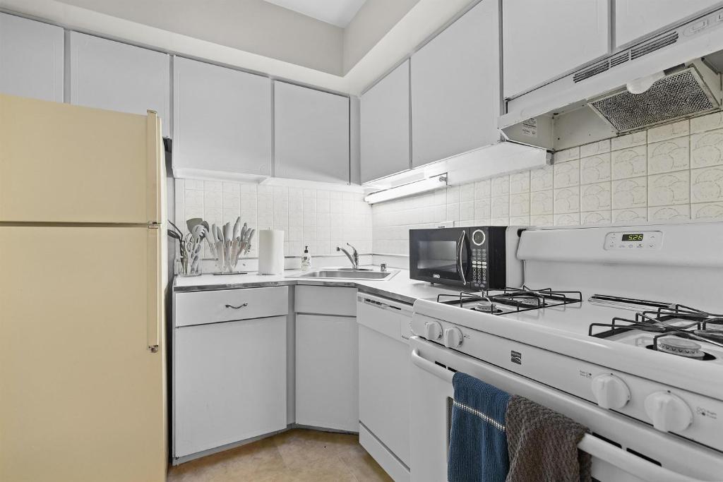 a white kitchen with a stove and a microwave at Your perfect stay - Cozy 2BR apartment in NOVA in Arlington