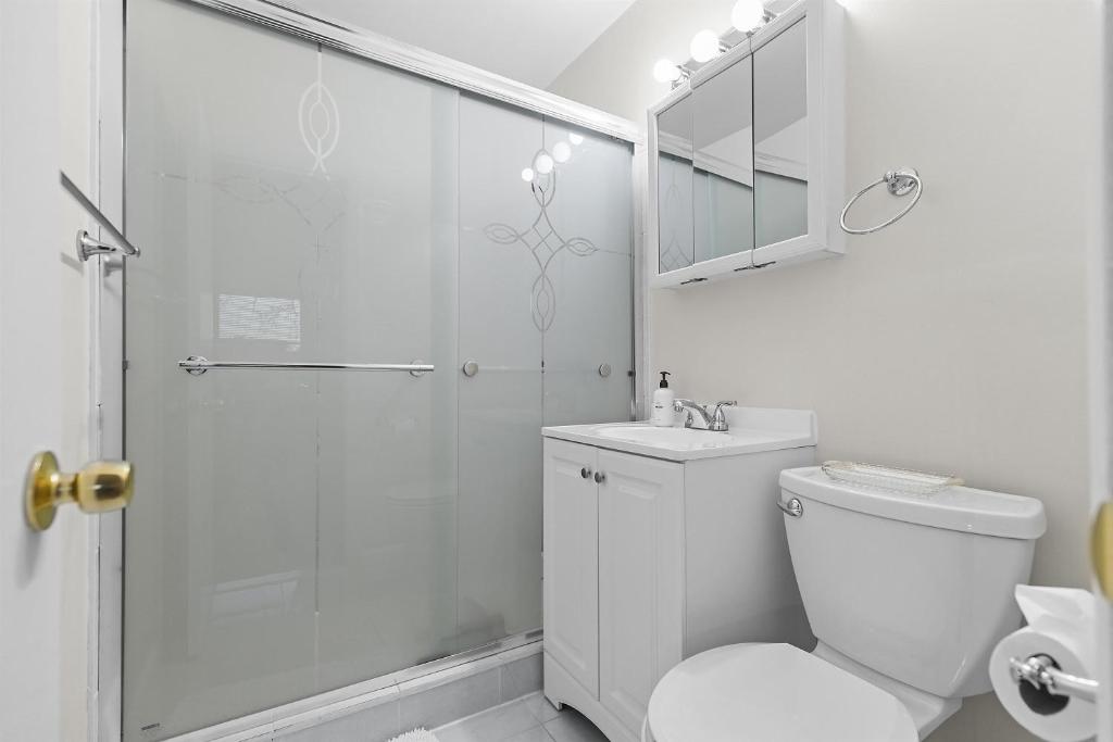 a white bathroom with a shower and a toilet at Your perfect stay - Cozy 2BR apartment in NOVA in Arlington