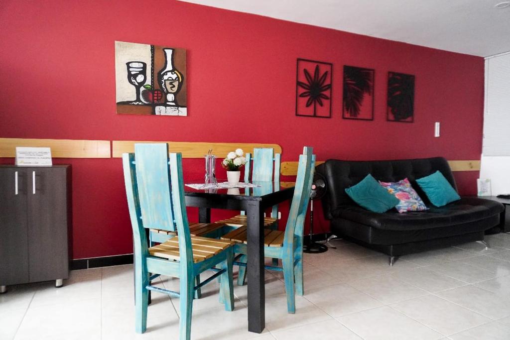 a dining room with a table and chairs and a couch at Apartamento cerca al parque del cafe in Montenegro