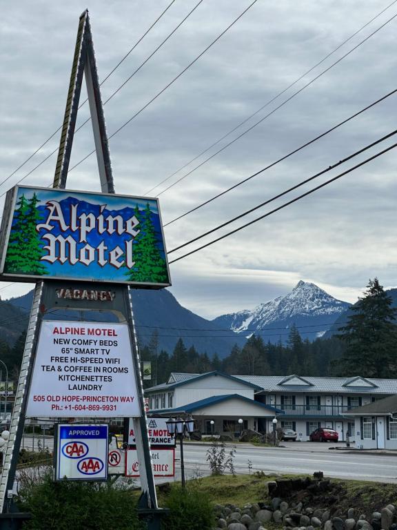 a sign for an airplane motel with a mountain in the background at Alpine Motel in Hope