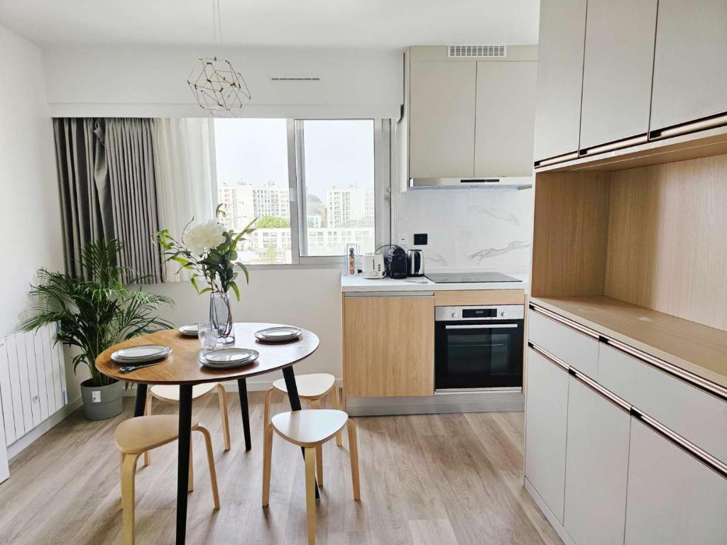 une cuisine avec une table et des chaises dans une cuisine dans l'établissement Charme cosy apt au coeur de paris, à Paris
