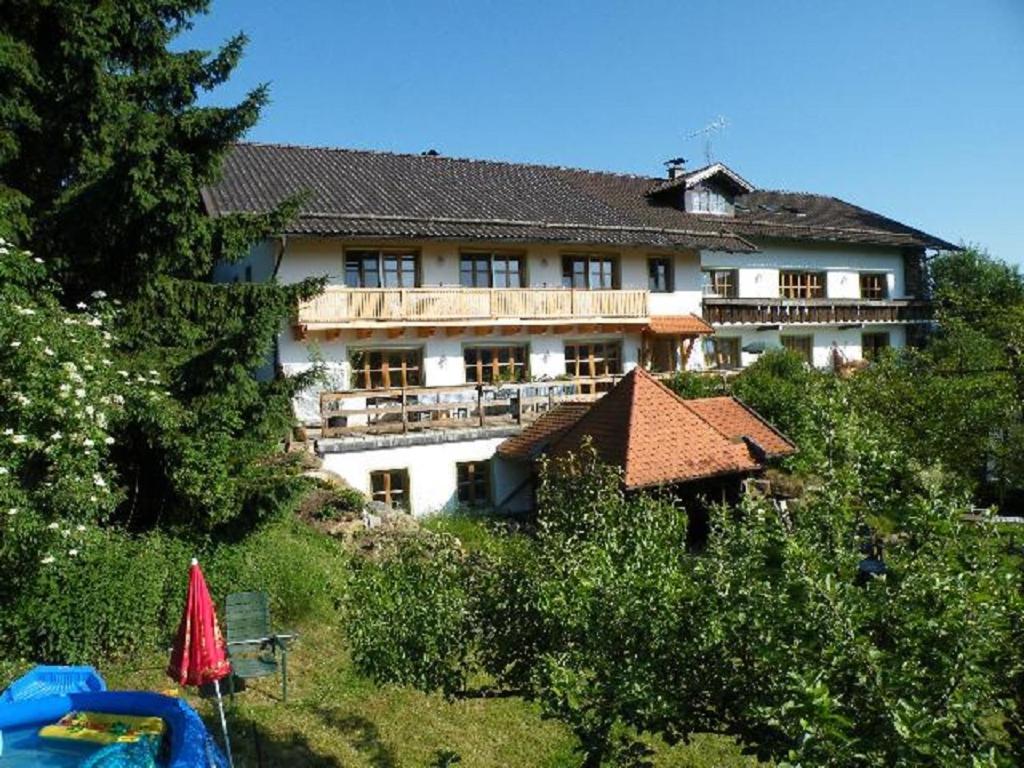 un gran edificio en la cima de una colina con árboles en Pension Landhaus Riedelstein, en Drachselsried