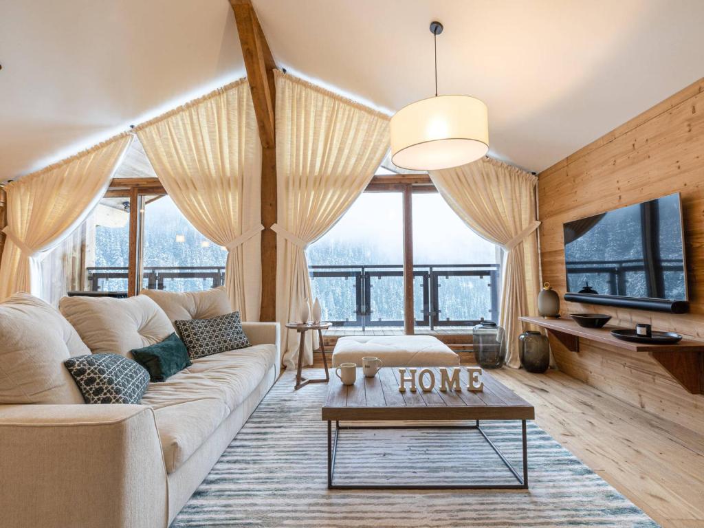 un salon avec un canapé et une table dans l'établissement Appartement haut de gamme à Courchevel 1650 avec garage, balcon et WiFi - FR-1-575-167, à Courchevel