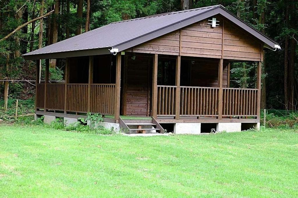 a small cabin with a porch in a field of grass at Shiobara Onsen Activity Club - Vacation STAY 86348v in Shiobara-machi