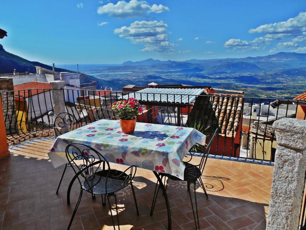 einen Tisch auf einem Balkon mit einer Blumenvase darauf in der Unterkunft Villa Maddalena in Baunei