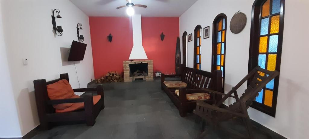 a living room with chairs and a fireplace at Casa da praia, Caraguatatuba in Caraguatatuba