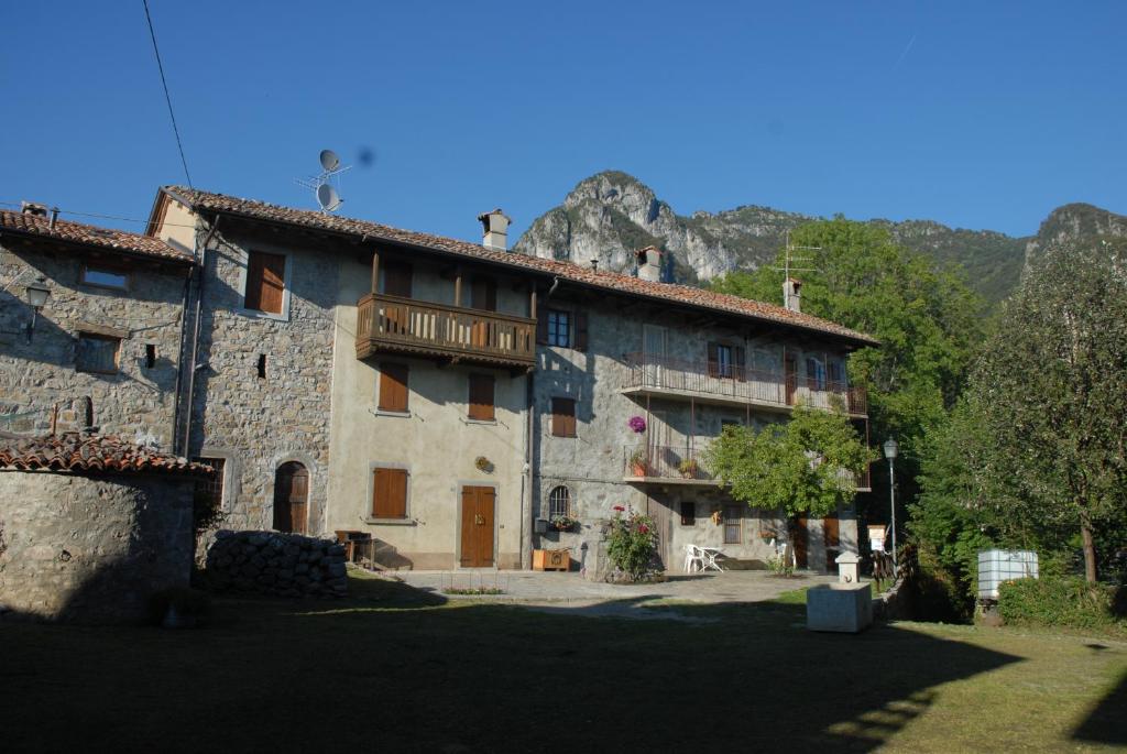 a large stone building with a mountain in the background at Bed & Breakfast Castello Regina in Brembilla