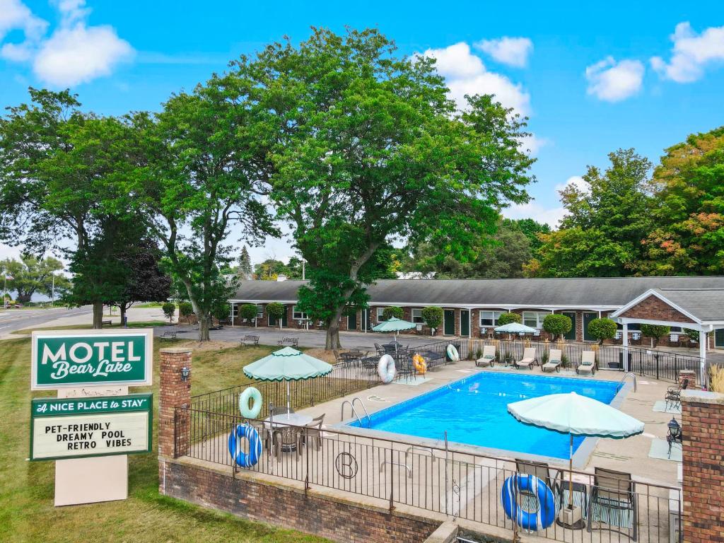Bear LakeにあるMotel Bear Lakeのパラソルと看板を持つホテルのプール