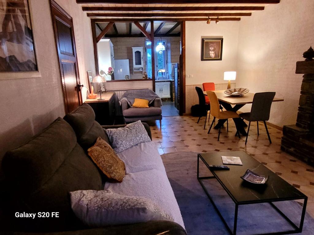 un salon avec un canapé et une table dans l'établissement T3 avec jouissance jardin dans ancien presbytere, à Saint-Mamet
