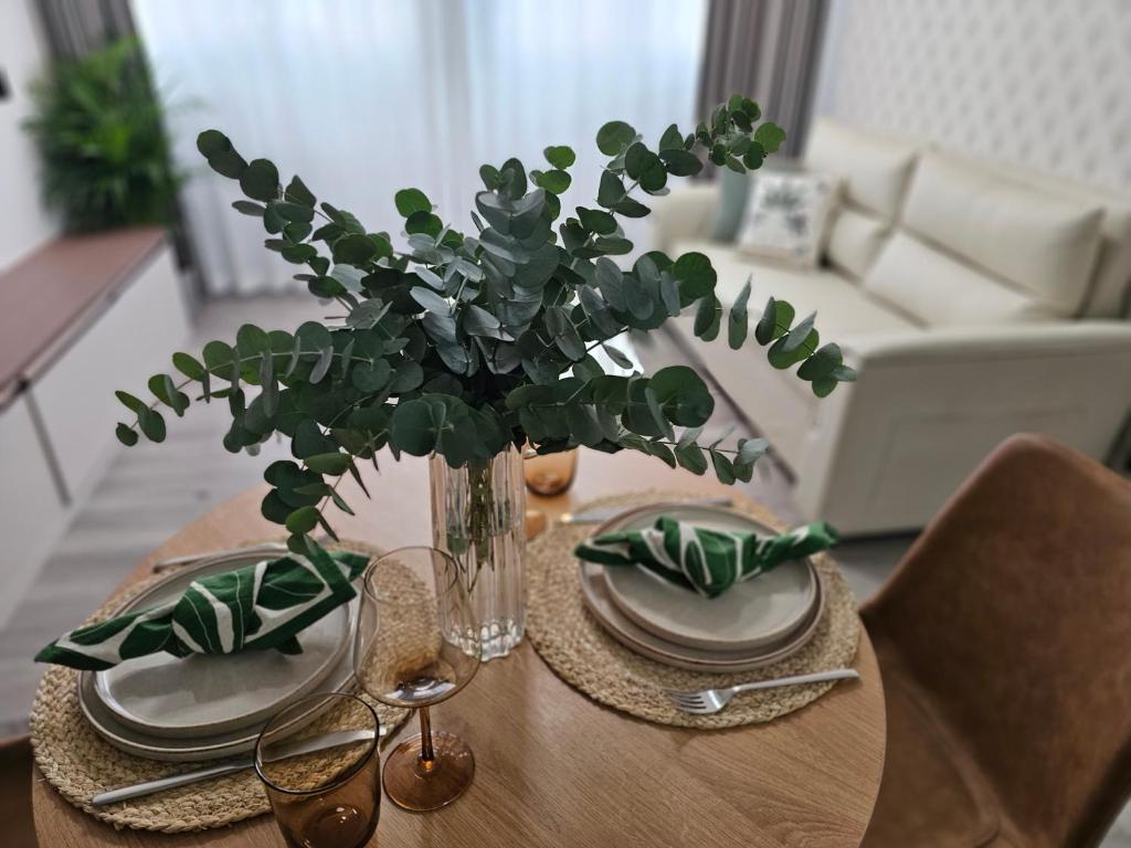 une table avec des assiettes et un vase avec une plante dans l'établissement apt cosy proche arena bercy, à Paris