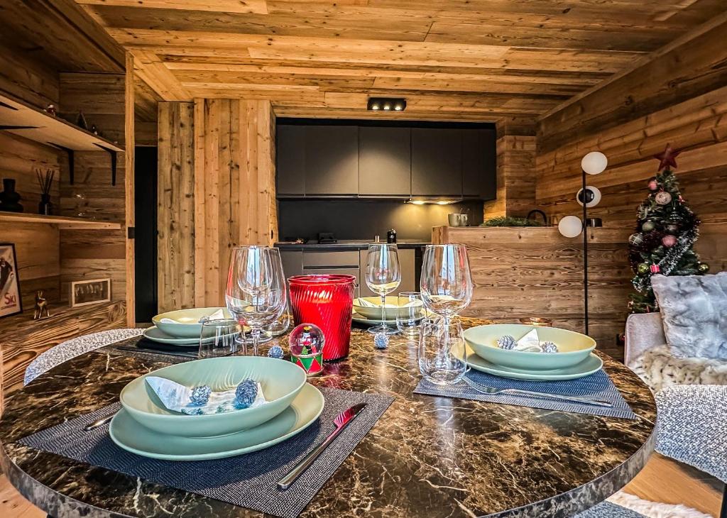 une table avec des assiettes et des verres dans une cabine dans l'établissement Stella Megeve Palais garage, à Megève