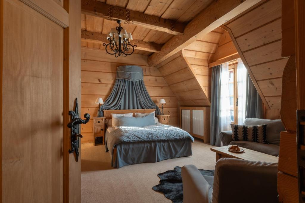 a bedroom with a bed in a log cabin at Willa Rajka in Zakopane