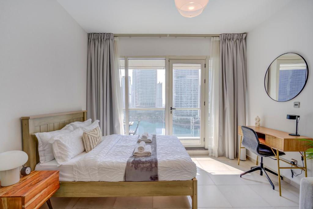 DA86 - Well Design Studio in Dubai Arch tower في دبي: غرفة نوم بسرير ومكتب ونافذة