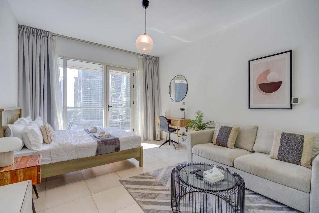 DA86 - Well Design Studio in Dubai Arch tower في دبي: غرفة معيشة مع سرير وأريكة