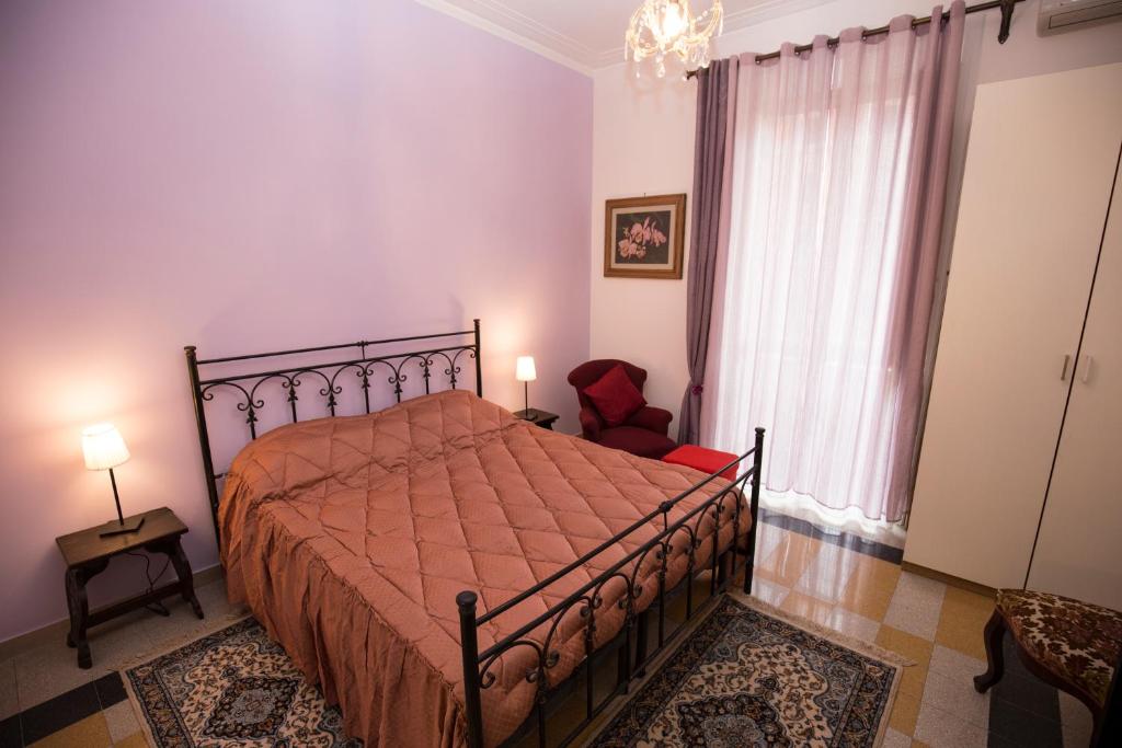 um quarto com uma cama, uma cadeira e uma janela em Giubiliana em Roma