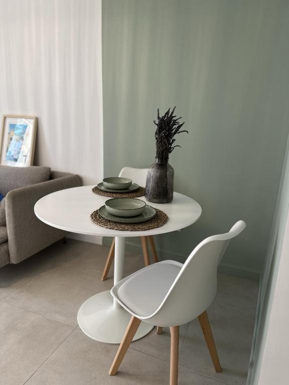 une table blanche et des chaises dans un salon dans l'établissement Le Camas Cosy - Rez de Jardin, à Marseille