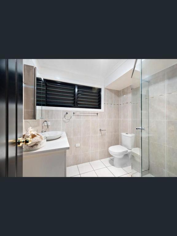 a bathroom with a toilet and a sink and a shower at Rakali Retreat in Cooran