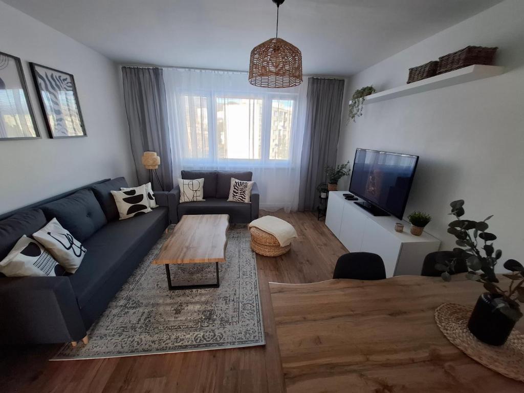 a living room with a blue couch and a table at Apartmán OLI Banská Bystrica in Banská Bystrica