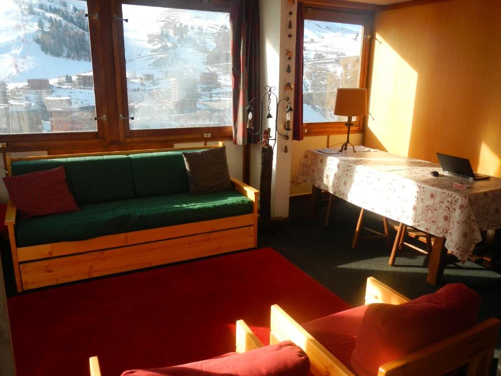 un salon avec un canapé vert et une table dans l'établissement Superbe appt ensoleillé au cœur de Plagne Centre, à La Plagne Tarentaise