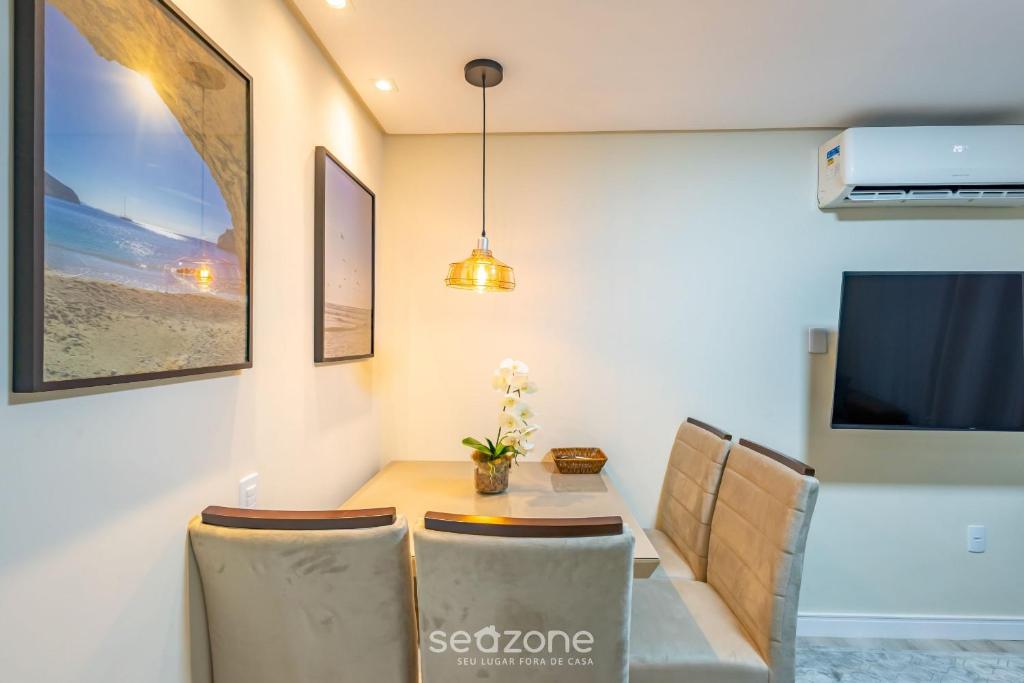 Apto 2Qtos centro BC a 160m da praia SRL002 في باليريو كامبوريو: غرفة طعام مع طاولة وكراسي وتلفزيون