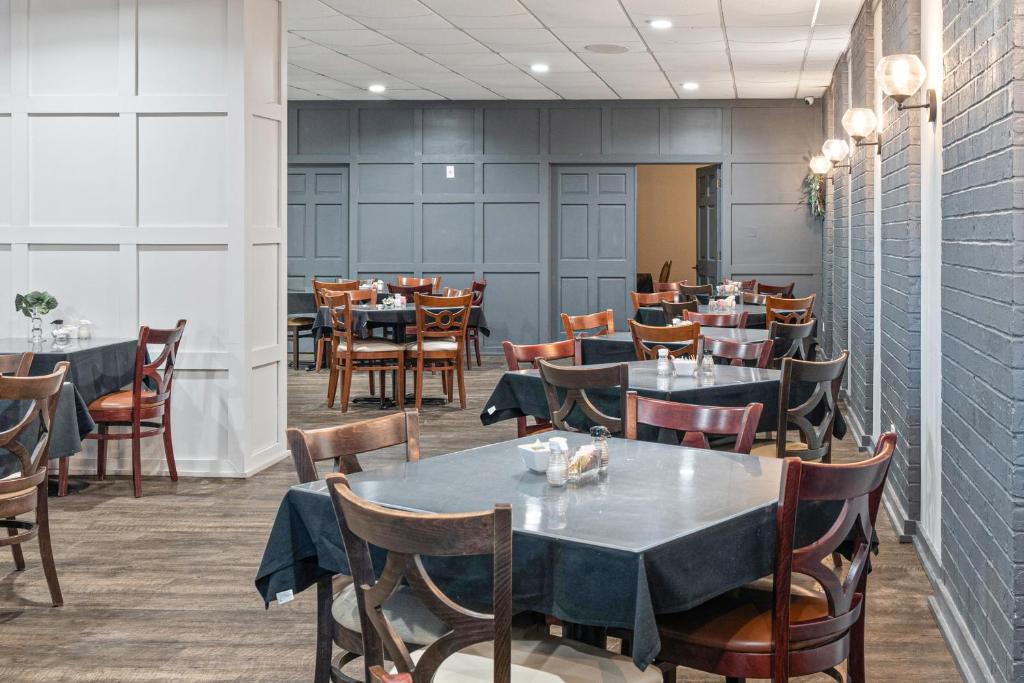a restaurant with tables and chairs in a room at Plantation Inn in Houma