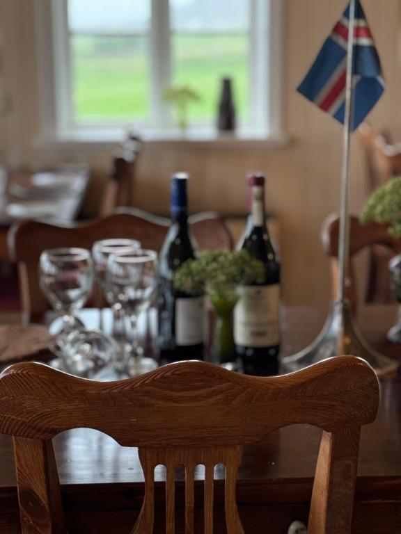 a wooden table with bottles of wine and a flag at Berunes HI Hostel in Berunes