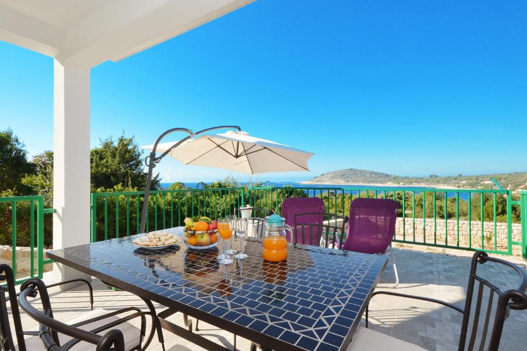 a table with fruit on it on a patio at Holiday Home Paradiso in Mali Drvenik