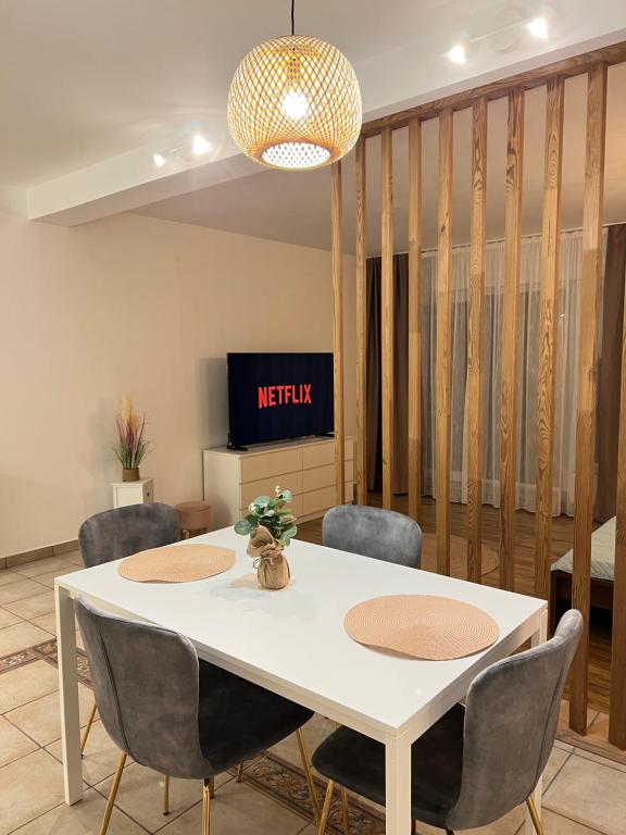 a dining room with a white table and chairs at Central Loft Studio Târgoviște in Târgovişte