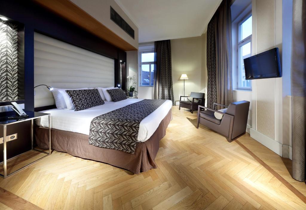 a bedroom with a large bed and a flat screen tv at Eurostars Thalia in Prague