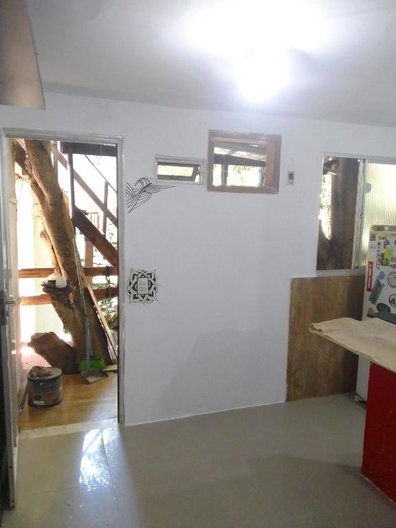 uma porta aberta para um quarto com uma escada em Kitnet na praia da Macumba no morro do Rangel no Rio de Janeiro