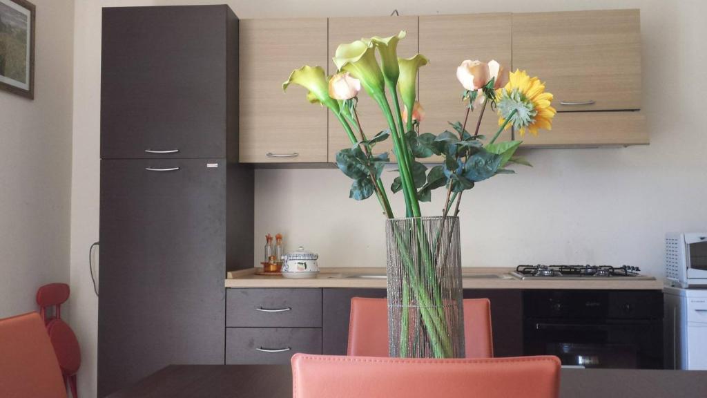 a vase of flowers sitting on a table in a kitchen at Centauro by PizzoApartments in Pizzo