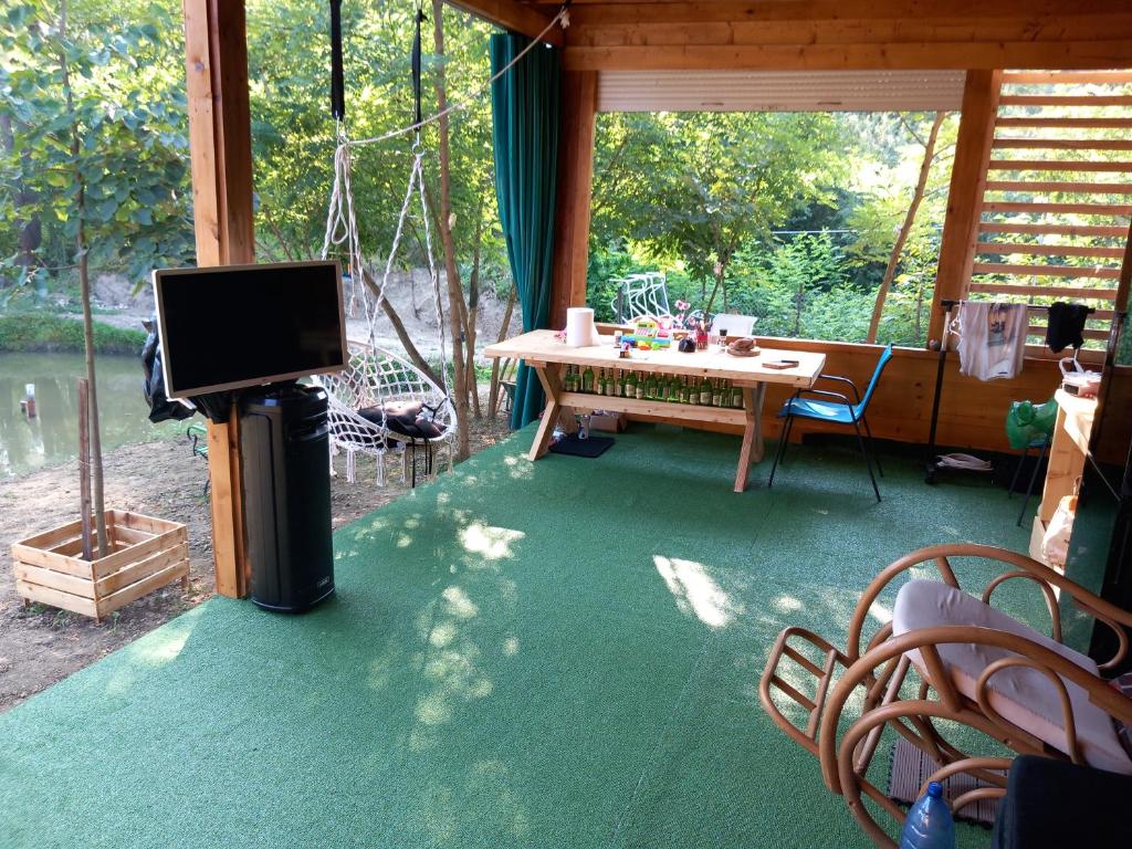 una veranda schermata con tavolo e TV di Cabana AFO A Frame a Brăteasca