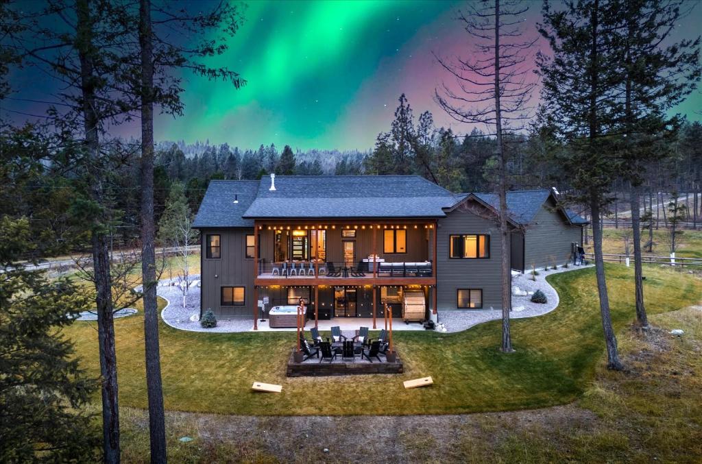an aerial view of a house with the aurora in the sky at Luxe Lakeside New Build by Flathead Lake Speakeasy in Somers