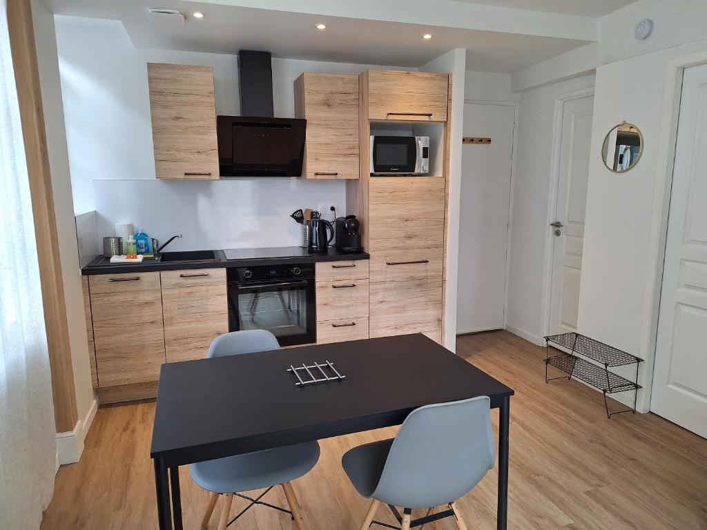 une cuisine avec une table et des chaises dans une pièce dans l'établissement Notre Dame 1 - Vue sur la Loire - Rdc - Hypercentre, à Orléans